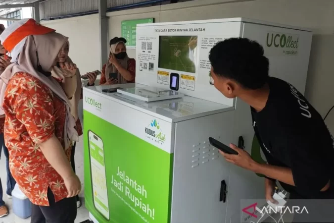Buruh pabrik rokok Djarum mencoba menyetorkan minyak jelantah ke mesin Ucollect (foto: ANTARA)