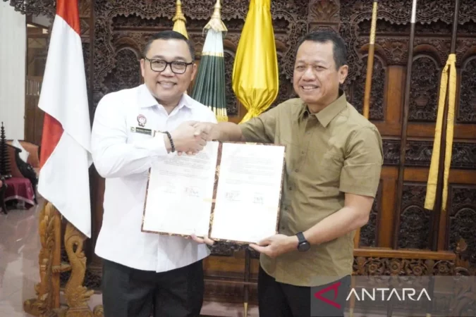 Kepala Kanwil Kemenkum Jateng Heni Susila Wardoyo menyerahkan surat Kekayaan Intelektual Komunal (KIK) kepada Bupati Kudus Sam'ani Intakoris di Pringgitan Pendopo Kabupaten Kudus, Rabu (24/9/2025) (foto: ANTARA)